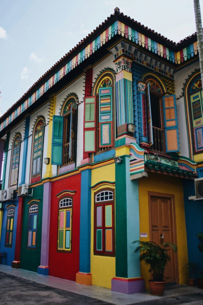 Un bâtiment de deux étages avec des détails architecturaux complexes et des murs, des portes et des fenêtres peints de couleurs vives dans différentes couleurs, notamment le rouge, le jaune, le bleu et le vert.